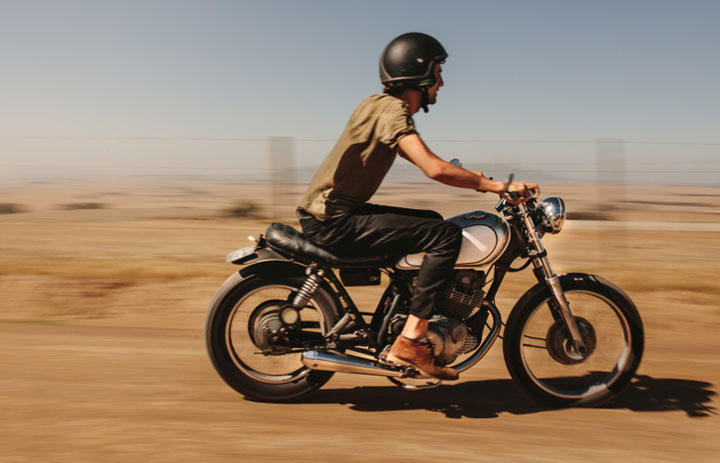  young man biker riding his bike on country road